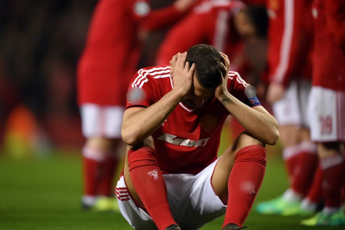 Player sitting on the ground with his hands on head