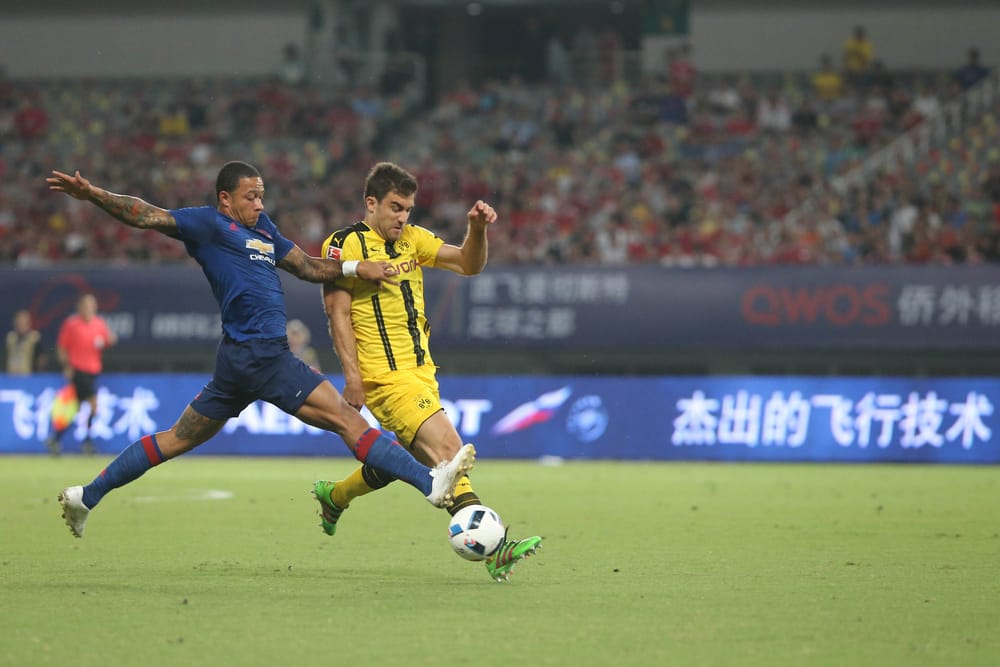 Memphis Depay, left, challenges Sokratis Papastathopoulos.